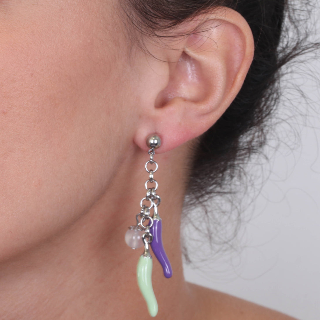 Metal earrings pending with lucky horns, embellished with colored glazes