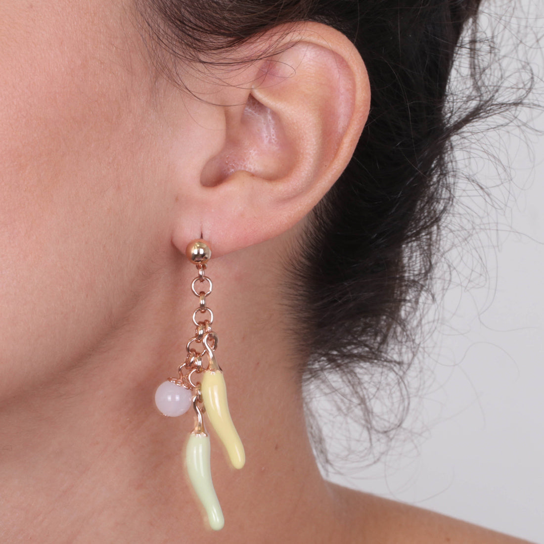 Metal earrings pending with lucky horns, embellished with colored glazes