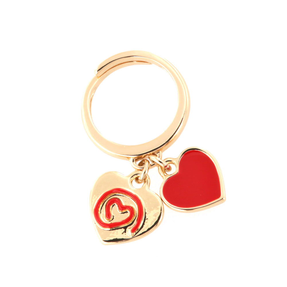 Metal ring with pendant charms, heart with in relief thread in red enamel and heart covered with enamel