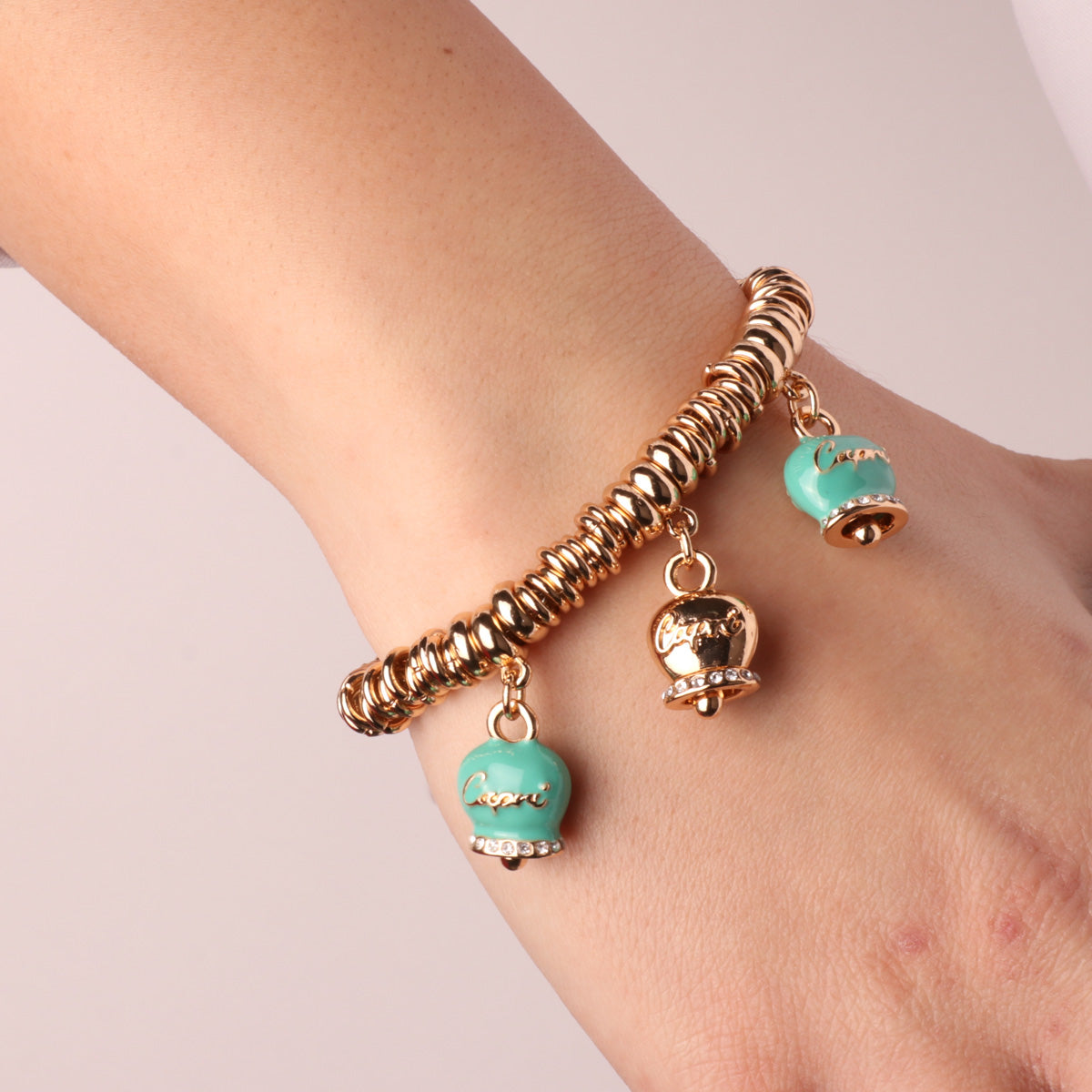 Metal bracelet with three pending bells with Capri writing and white crystals