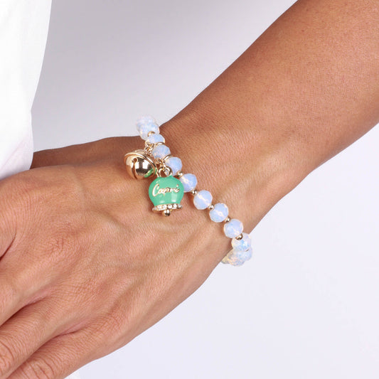 Metal bracelet with green bell and small rattle with white stones