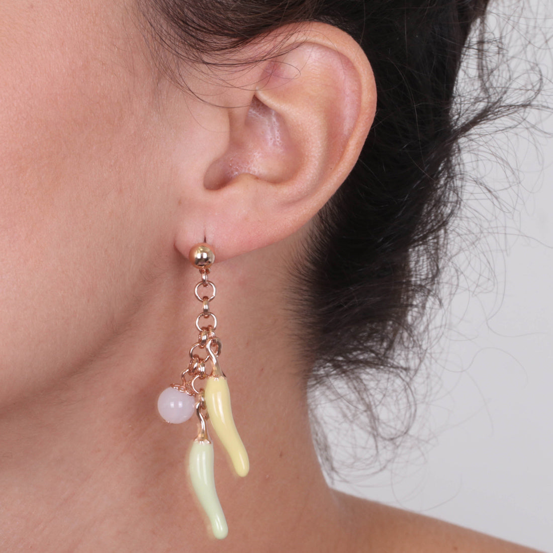 Metal earrings pending with lucky horns, embellished with colored glazes