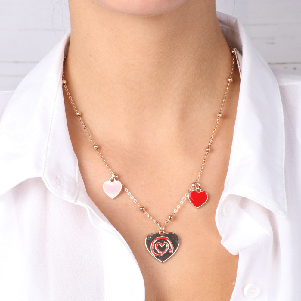 Metal necklace with pendant heart and red wire of the heart in and two pending lateral hearts
