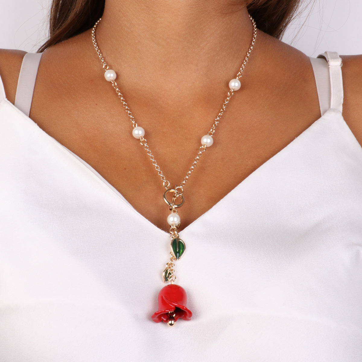 Metal necklace with t -closure and bell pendant in the shape of red rose and leaves