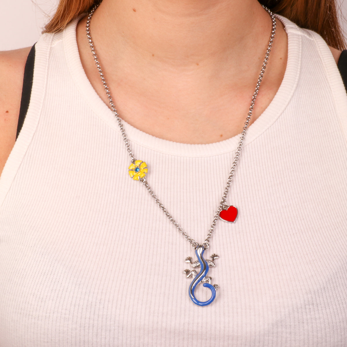 Metal necklace with central geco, yellow flower and red heart