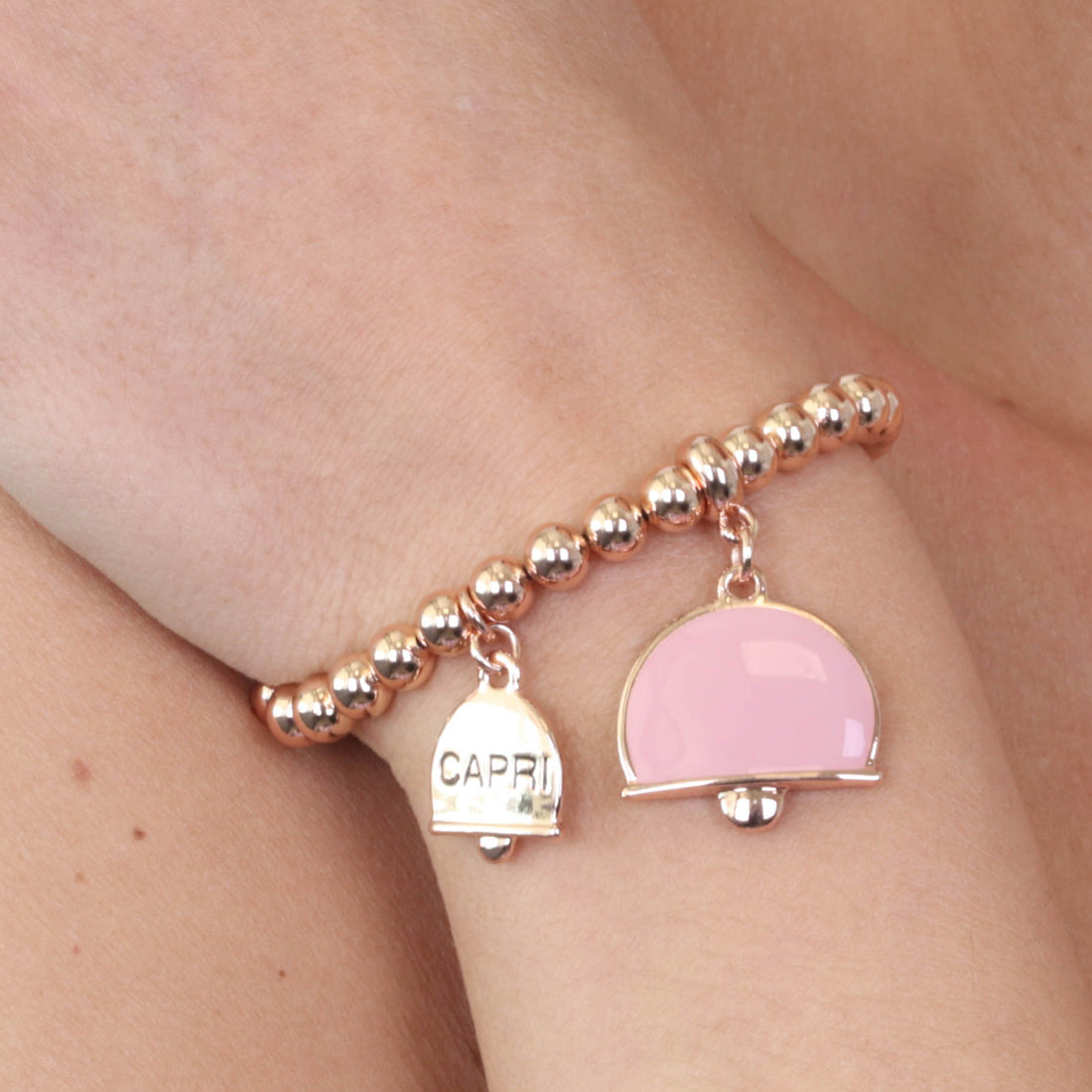 Metal bracelet spheres shirt, with dual crushed bell charm, embellished with pink enamel