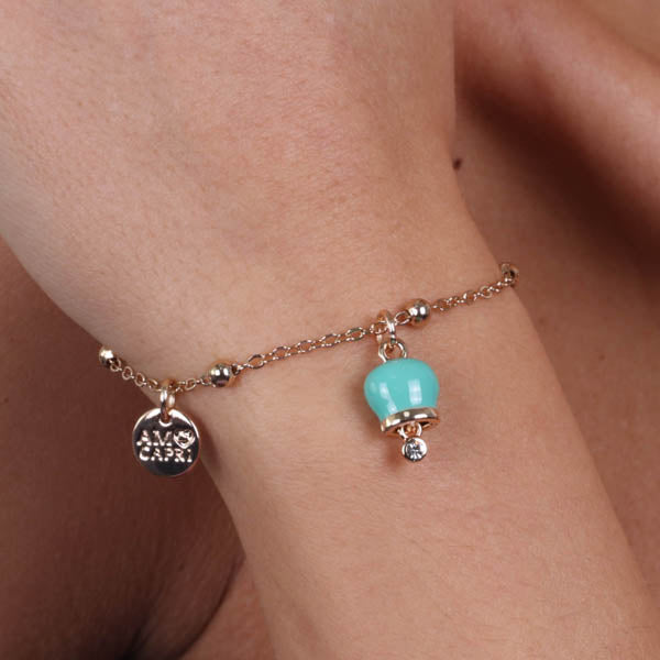 Metal bracelet with pendant charm bell, embellished with green enamel and light point