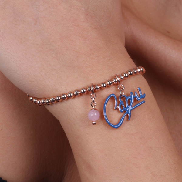 Metal bracelet with capri writing pending blue enamel and pink bead