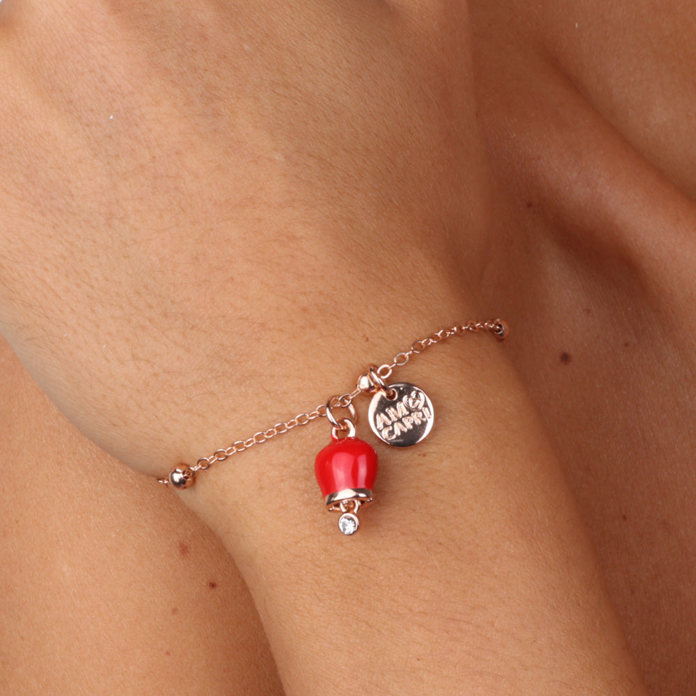 Metal bracelet with pendant charm bell, embellished with red enamel and light point