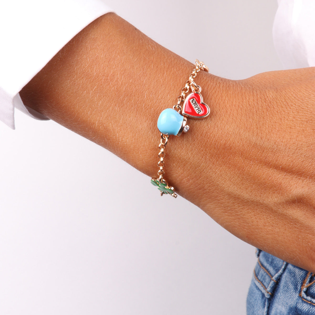 Metal bracelet with charming bell, heart with capri writing and sun with white pearl