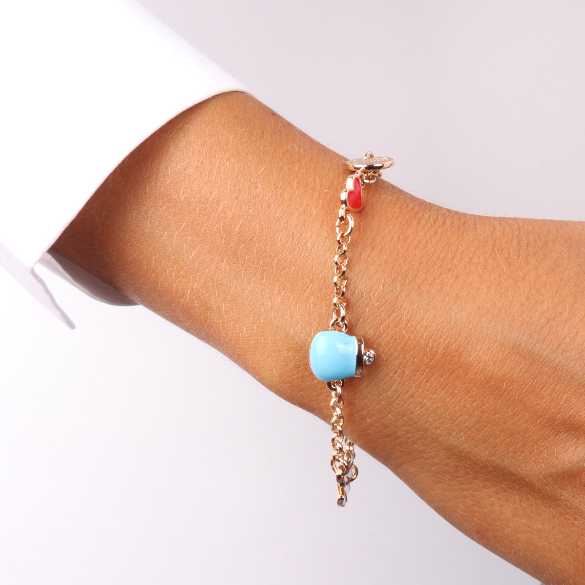 Metal bracelet with pendants embellished with colored enamels in the shape of a charming bell, heart and flower