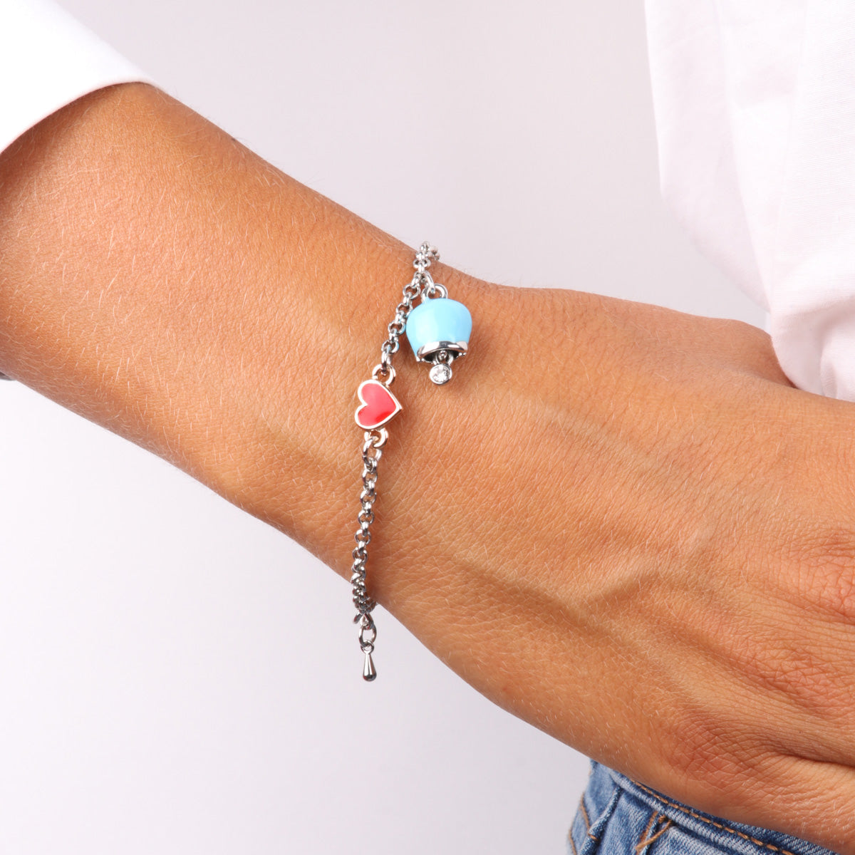 Metal bracelet with bell nogging blue changing and pendant in the shape of a red glazed heart shape and detail