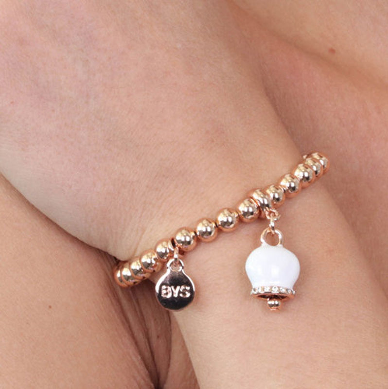 Metal bracelet spheres shirt, with a pendant charm bell, embellished with white enamel and crystals